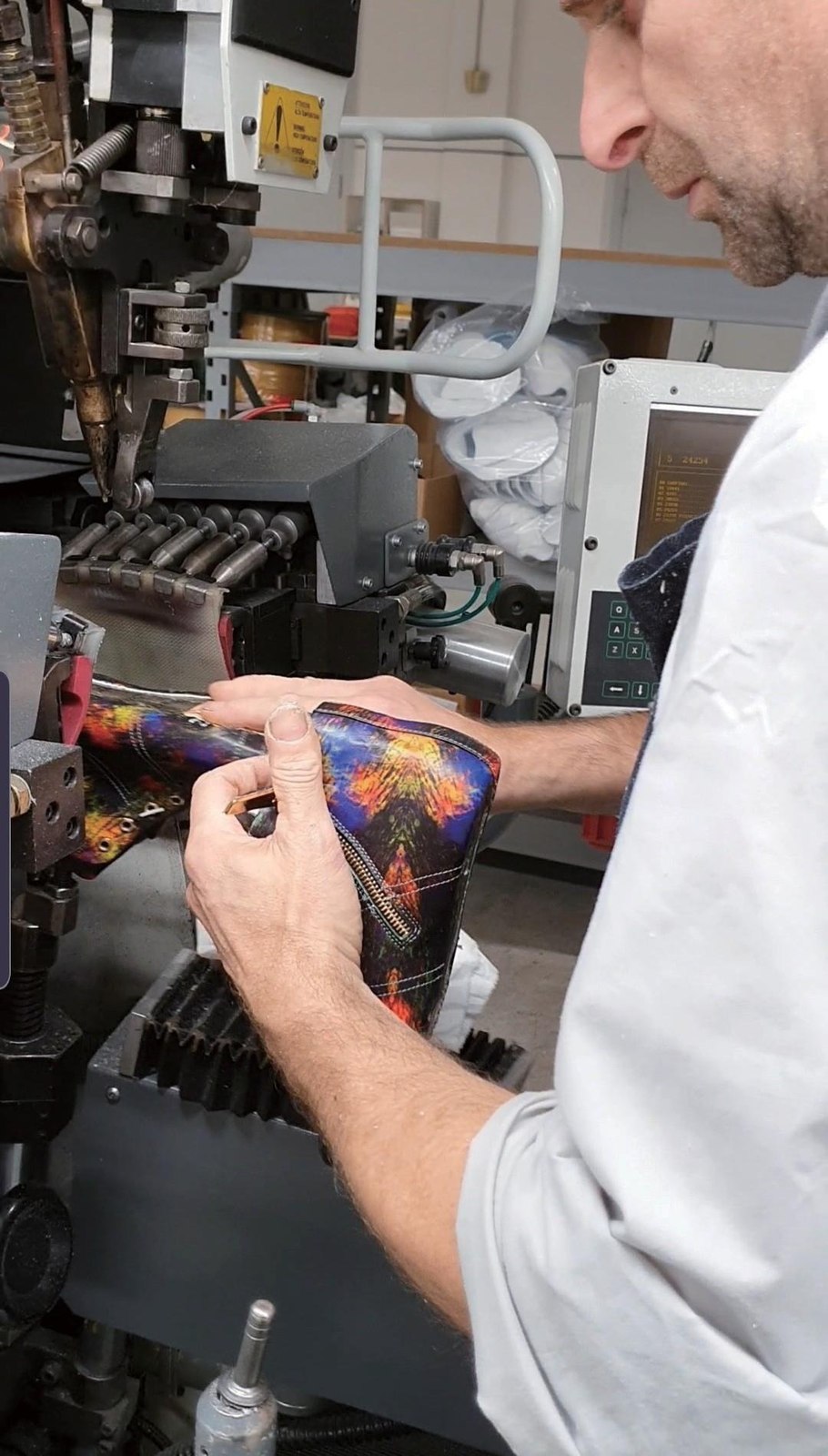 A craftsman applying colour and pattern to leather