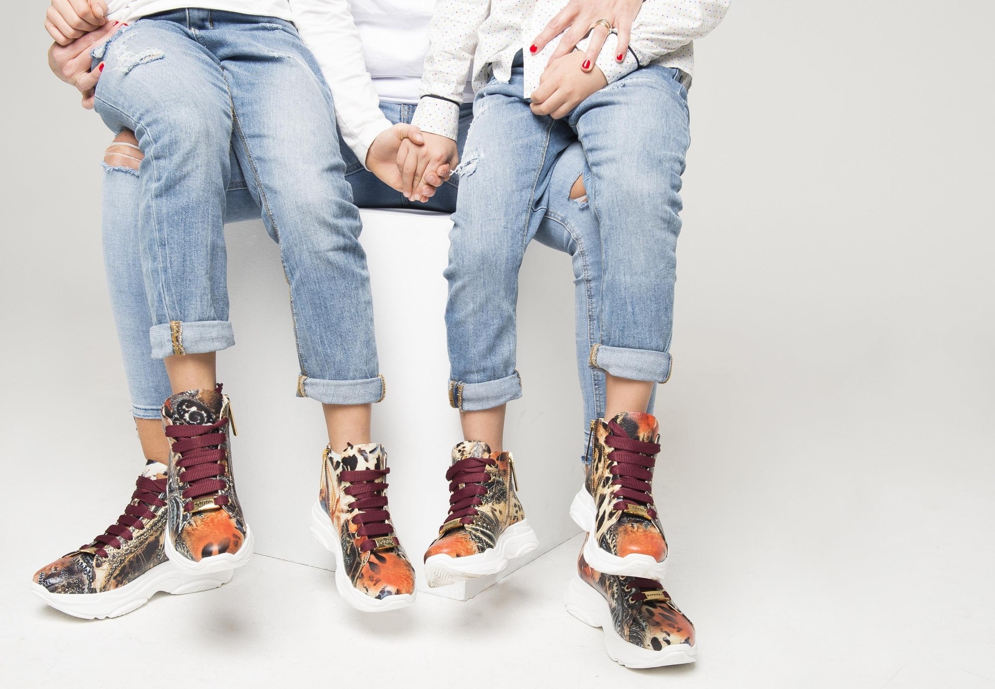Three people wearing colourful RIPRESA ITALY sneakers