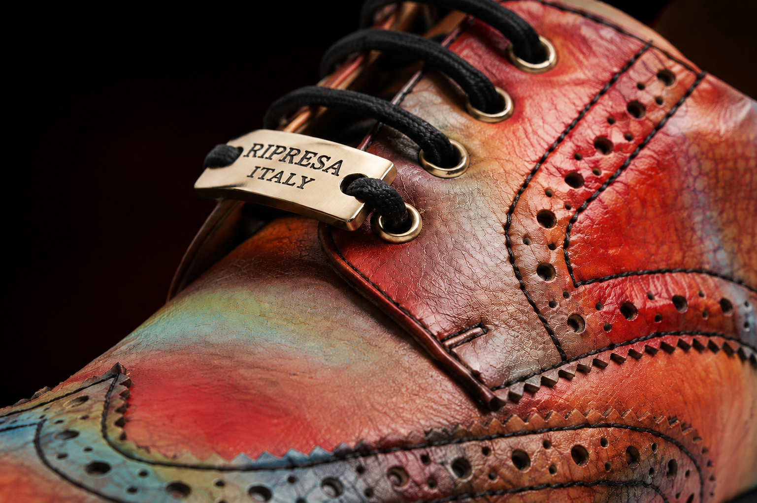 Close view of RIPRESA ITALY printed leather, brogue stitching and metal lace plate
